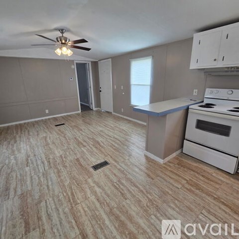 A kitchen with a white stove and a fan on the ceiling.