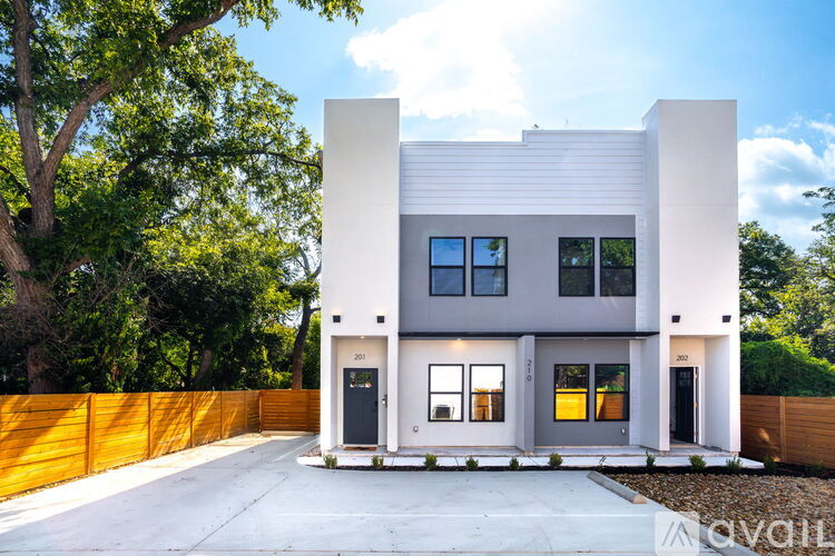 A modern two-story house with a white exterior and a grey roof.