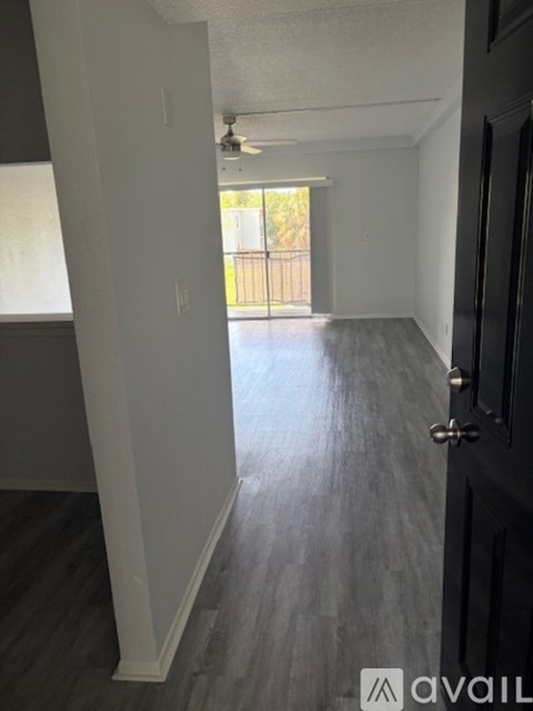 A room with a black door and grey flooring.