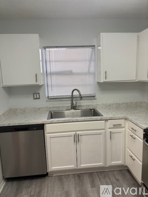 A kitchen with white cabinets and a stainless steel dishwasher.