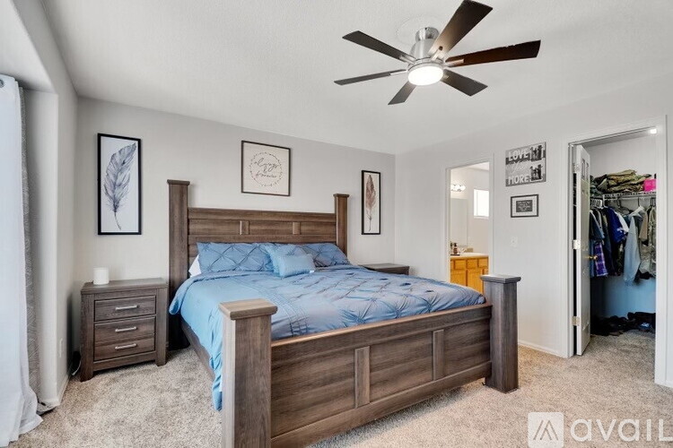 A bedroom with a bed, nightstands, and a ceiling fan.