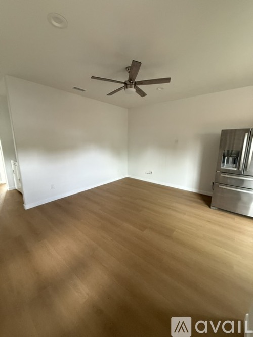 A room with wooden flooring and a ceiling fan.