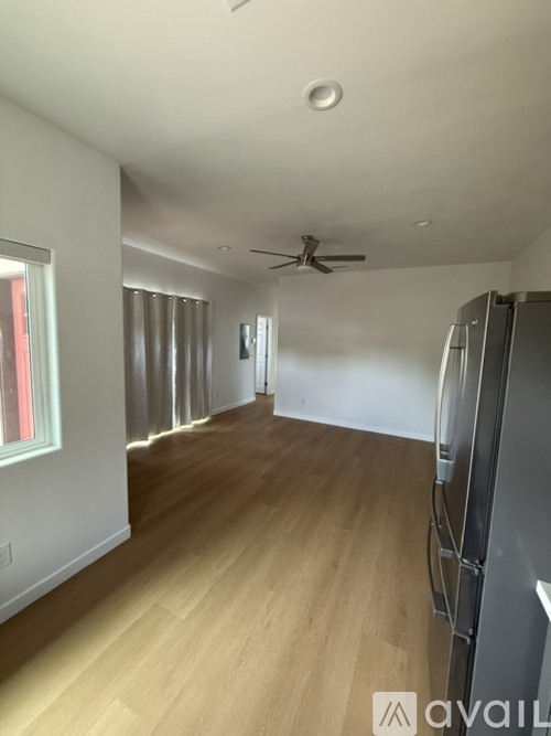 A room with a ceiling fan and wooden flooring.