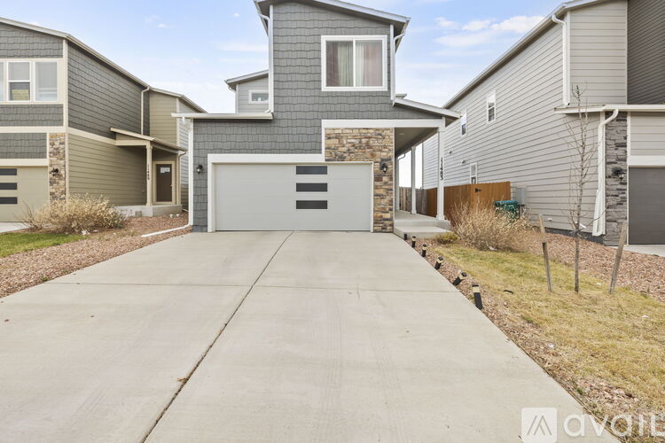 A modern house with a grey garage door is for sale.