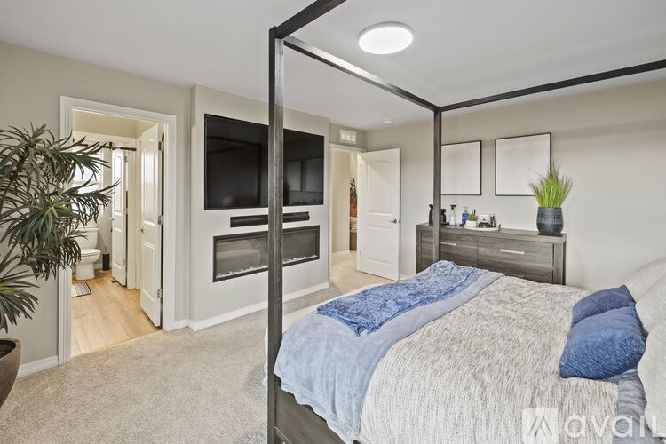 A bedroom with a four poster bed and a television.
