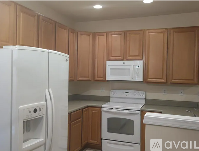 A kitchen with wooden cabinets and white appliances.