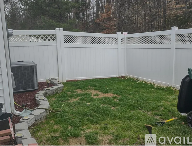 A white fence encloses a small grassy yard.