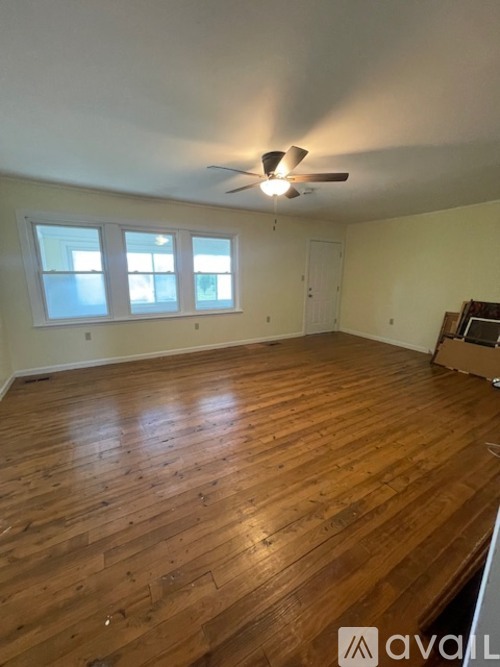 A room with wooden flooring and a ceiling fan.