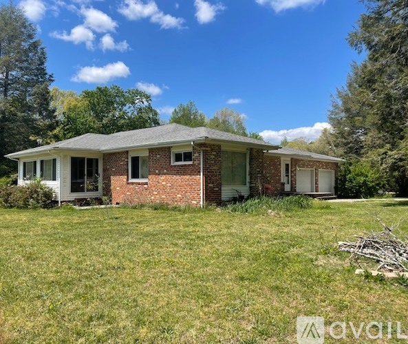 A house with a grassy yard in front of it.