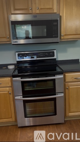 A modern kitchen with a stainless steel oven and microwave above it.