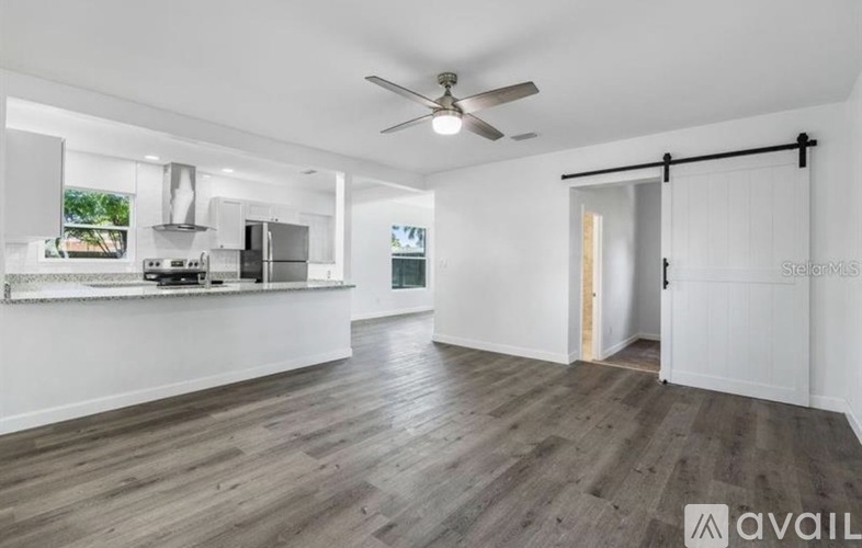 A spacious room with a sliding door leading to another room.