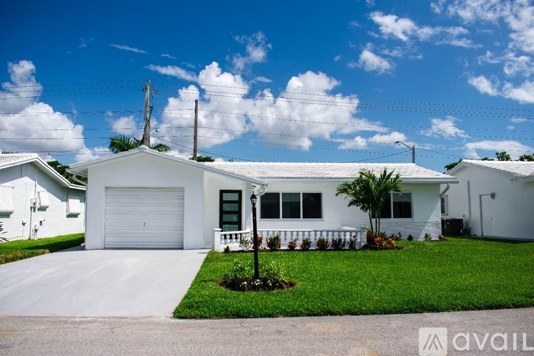 A white house with a driveway in front of it.