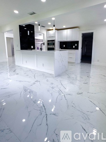 A kitchen with a marble floor and white cabinets.