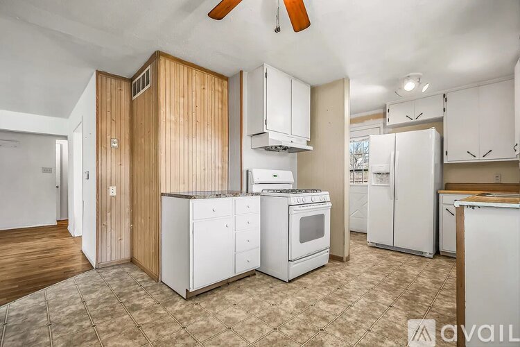 A kitchen with white appliances and wooden cabinets.