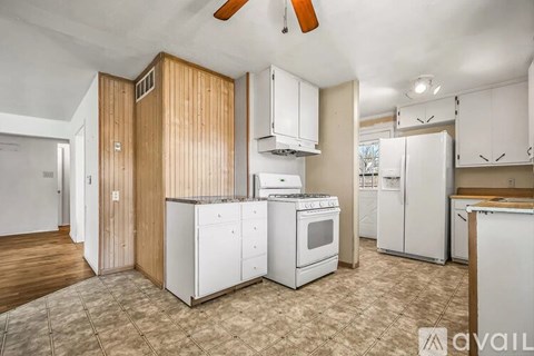 A kitchen with white appliances and wooden cabinets.
