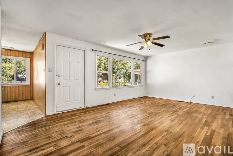 A room with wooden floors and a ceiling fan.
