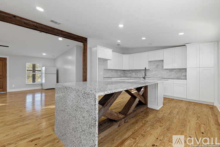 A kitchen with white cabinets and a granite countertop.