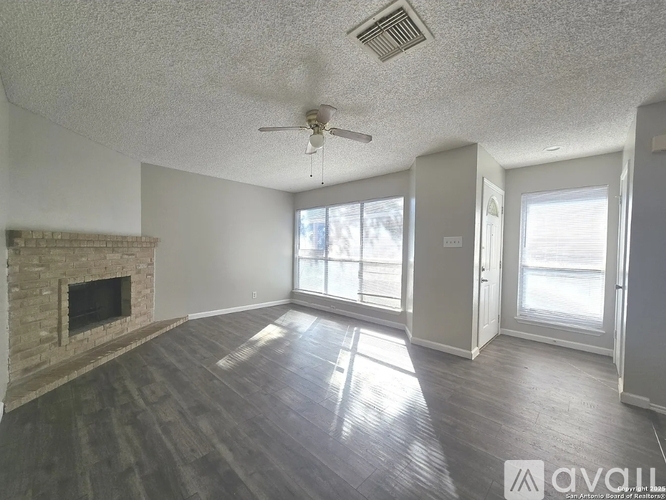 A living room with a fireplace and wood flooring.