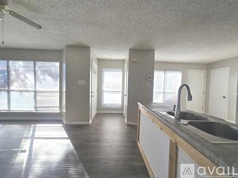 A kitchen with a sink, a window, and a ceiling fan.