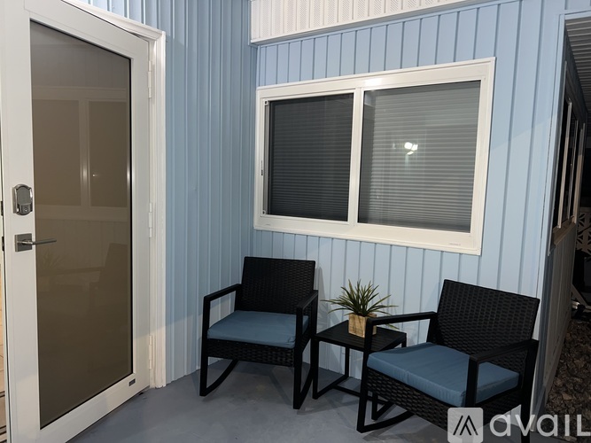 Two black chairs are placed in front of a blue wall.