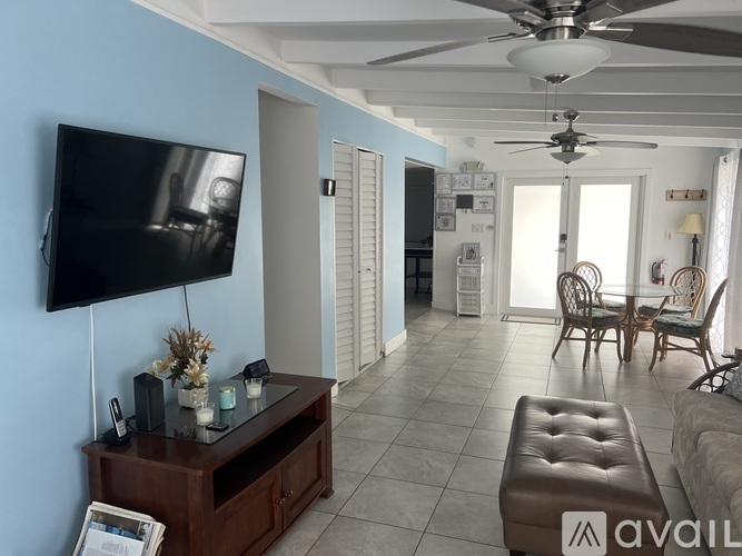 A living room with a flat screen TV mounted on the wall.