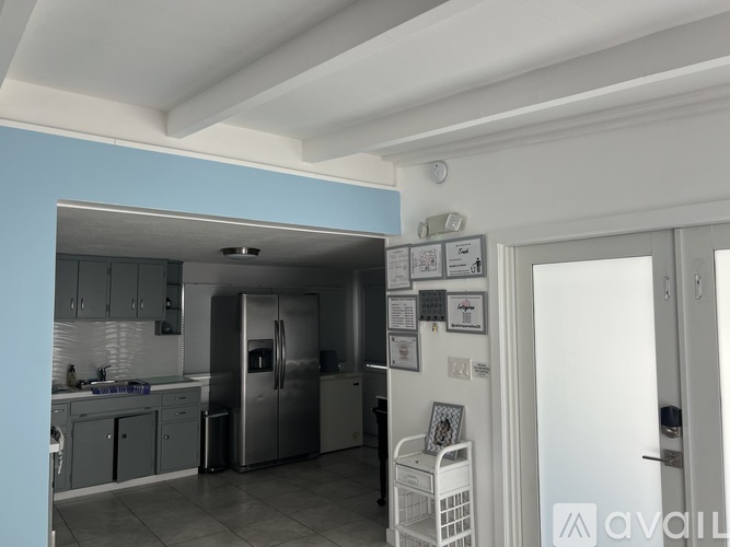 A kitchen with a refrigerator, sink, and cabinets.