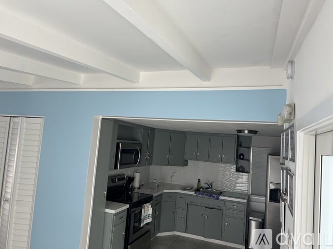 A kitchen with a blue wall and white ceiling.