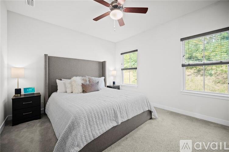 A bedroom with a large bed and a ceiling fan.