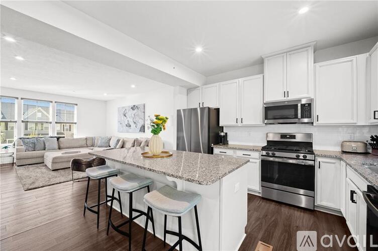 A modern kitchen with white cabinets and stainless steel appliances.