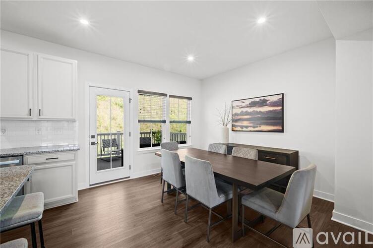 A dining room with a wooden table and chairs.