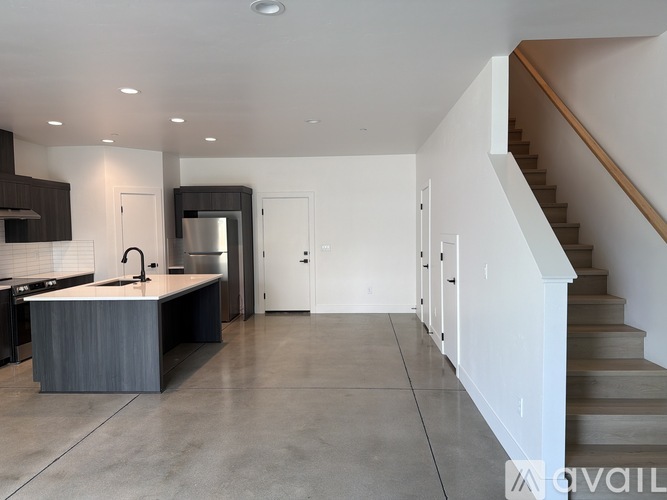 A modern kitchen with a stainless steel refrigerator and a sink.