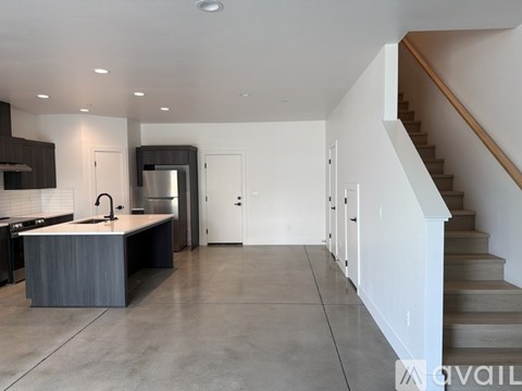 A modern kitchen with a stainless steel refrigerator and a sink.