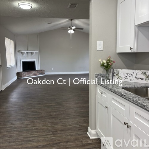 A kitchen with white cabinets and a wooden floor.