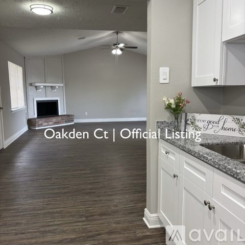 A kitchen with white cabinets and a wooden floor.