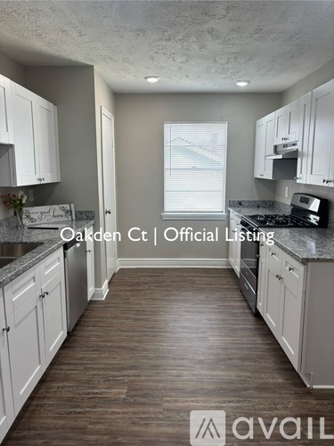 A kitchen with white cabinets and a marble countertop.