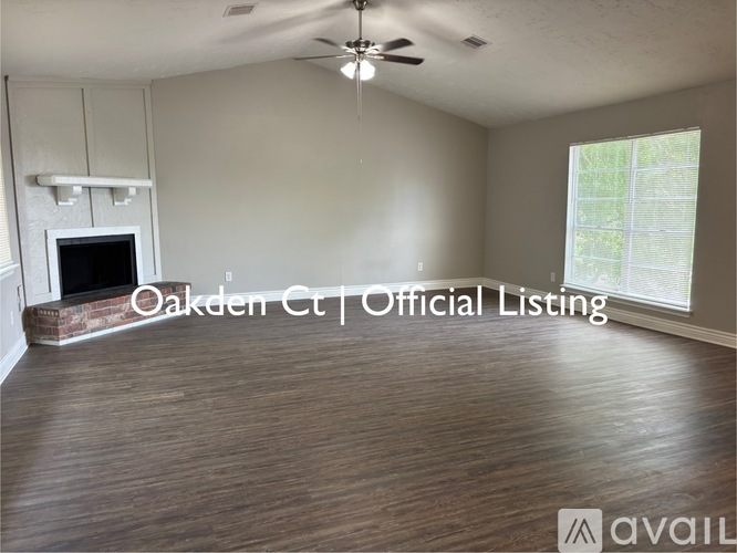 A spacious room with a fireplace and a ceiling fan.