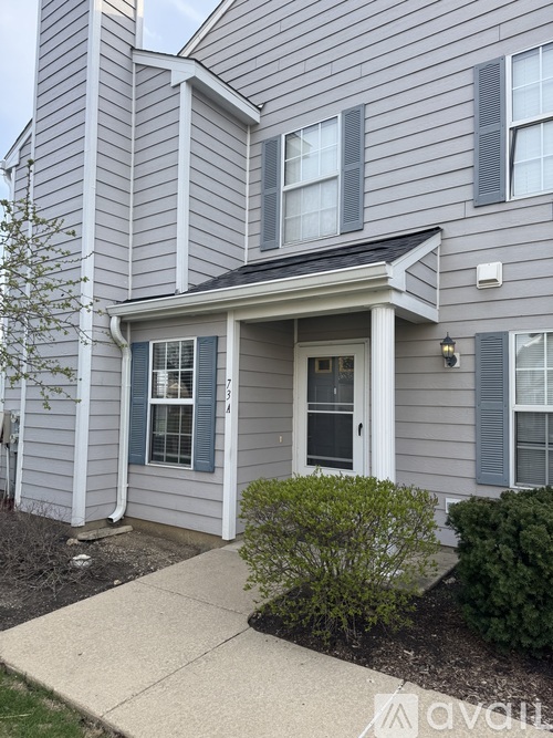 A grey house with a white door and windows.