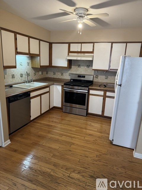 A kitchen with wooden floors and white appliances.