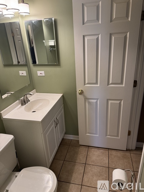 A white toilet sits next to a sink in a bathroom.