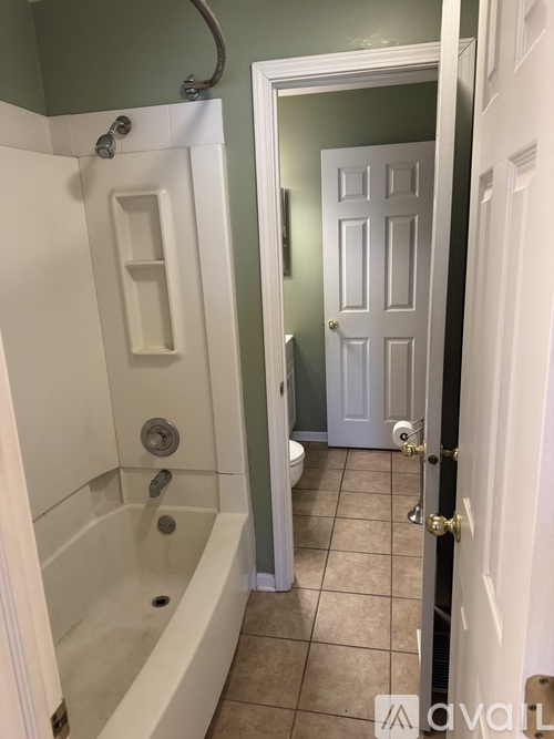 A bathroom with a white tub and a white door.