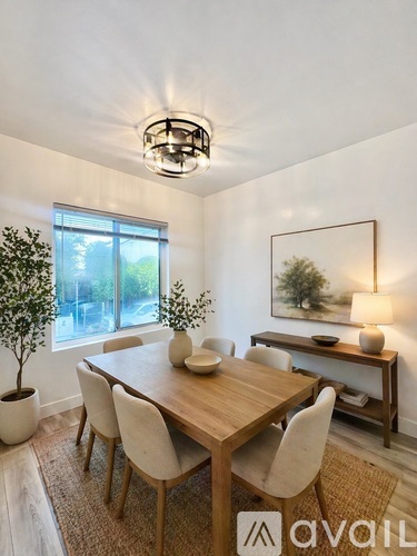 A dining room with a wooden table and chairs.