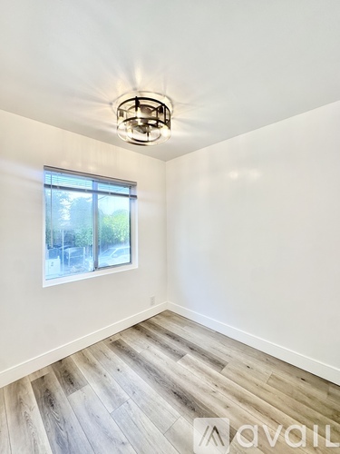 A room with a window and wooden flooring.