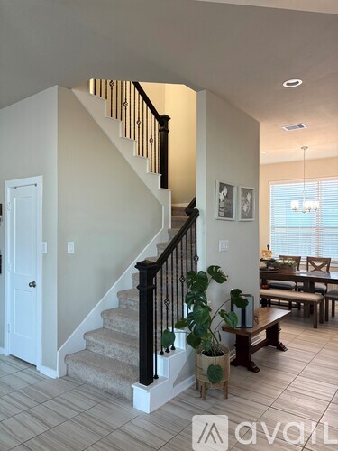 A living room with a staircase and a dining table.