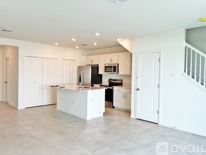 A kitchen with white cabinets and appliances is shown.
