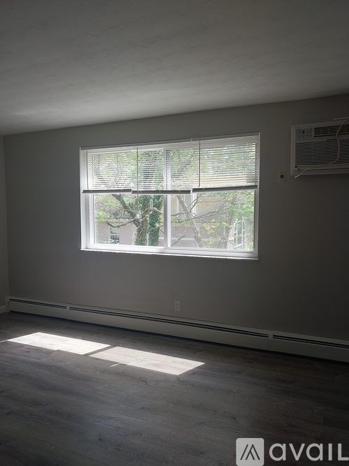 A room with a large window and a view of trees outside.