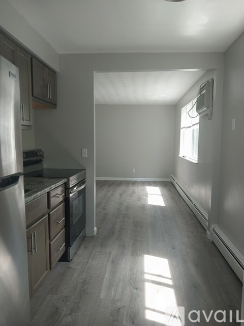 A kitchen with a refrigerator, oven, and cabinets.