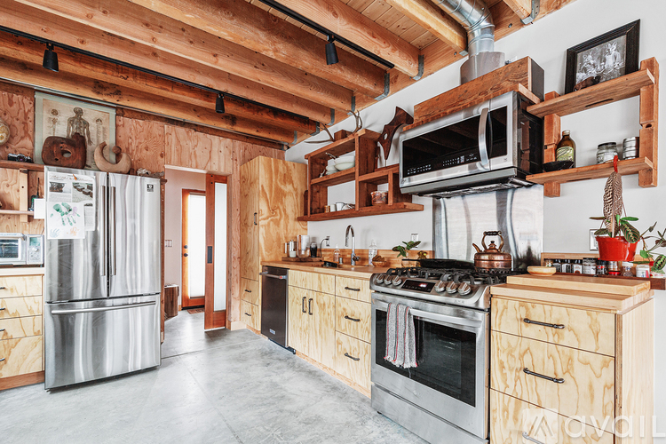 A kitchen with wooden cabinets and a stainless steel refrigerator.