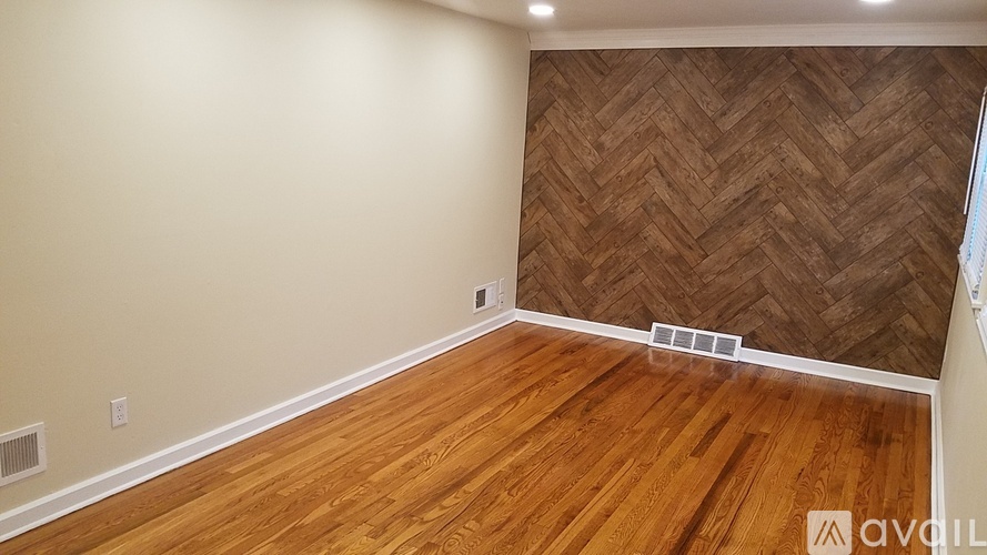 A room with wooden flooring and a herringbone patterned wall.