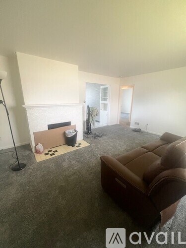 A living room with a brown couch and a fireplace.