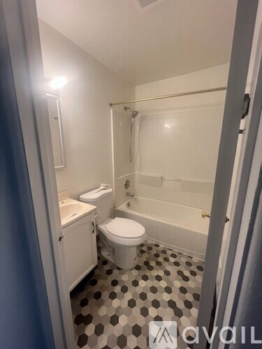 A bathroom with a toilet, sink, and shower.